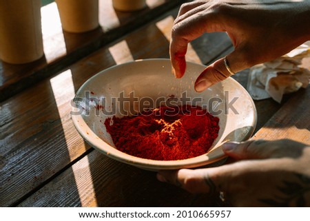 A dry paprika powder. A woman cooks festival food in the sunlight. Asian cuisine tradition