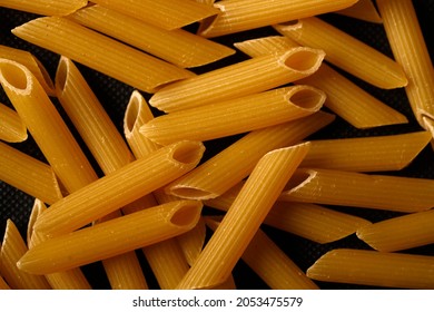 Dry pasta. Top view on black background. Detail of Macaroni pasta useful as a background, texture. Diet and food concept. . High quality photo