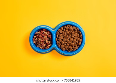 Dry Pet Food In Bowl On Yellow Background Top View