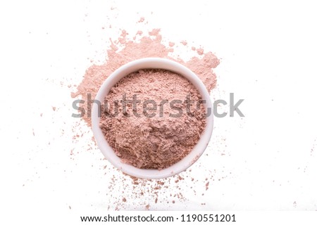 Dry pink clay powder mask for face and body  in ceramic bowl isolated on white