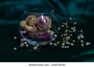 Dry Pink Roses In A Round Glass Vase On An Emerald Background