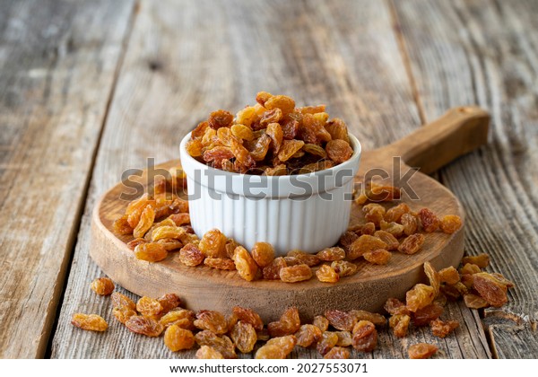 Dry raisins. Dry raisins nuts\
on wood floor. Bulk raisins grains. Raisins on a ceramic\
plate