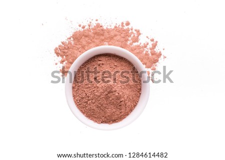 Dry red clay powder mask for face and body  in ceramic bowl isolated on white