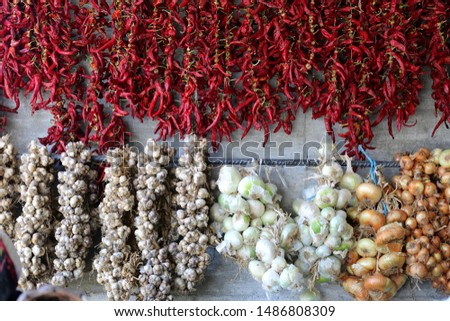 Dry red pepper garlic and onion hanging on the wall at the local market  in Albania.
