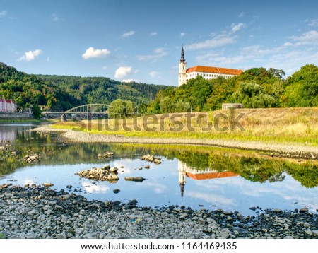 Dry riverbed of river Elbe in Decin, Czech Republic, summer 2018. Empty river bed with poisoned muddy water. Decin castle above old railway bridge.