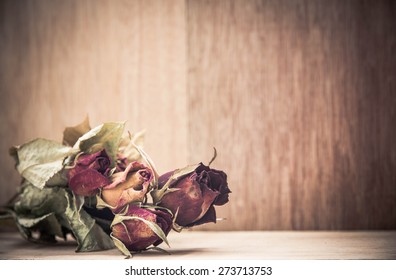 Dry roses on  wooden background,vintage and retro color tone,still life
