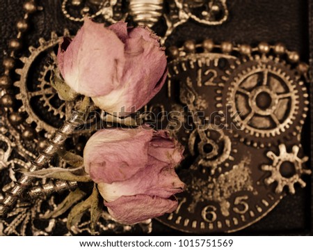Dry roses with screws instead of stems against the background of gears and a clock mechanism, sepia toned (as a steampunk concept or background), selective focus