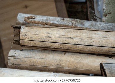 Dry split bamboo poles and a rusty metal hook resting together
