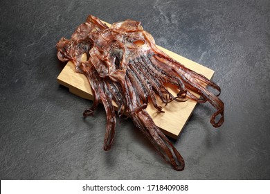 Dry squid legs photographed on dark gray background