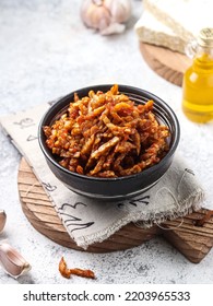 Dry Tempeh (kering Tempe), A Typical Indonesian Dish As A Side Dish For The Main Side Dish. Served In A Bowl On A Wooden Cutting Board On A White Background