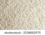 Dry Uncooked White Rice Background - Top View, Flat Lay. Scattered Raw Long Grain Rice. Asian Cuisine and Culture. Healthy Eating Ingredients. Diet Food