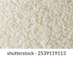 Dry Uncooked White Rice Background - Top View, Flat Lay. Scattered Raw Long Grain Rice. Asian Cuisine and Culture. Healthy Eating Ingredients. Diet Food