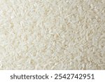 Dry Uncooked White Rice Background - Top View, Flat Lay. Scattered Raw Long Grain Rice. Asian Cuisine and Culture. Healthy Eating Ingredients. Diet Food