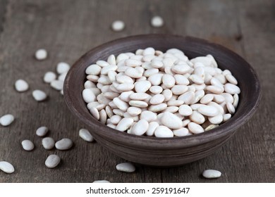 Dry White Baby Lima Beans In A Clay Bowl On Wooden Table, Selective Focus