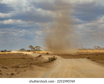 Dry winding road and dust tornado on the plain of savannah in Amboseli National Park, Kenya, Africa - Shutterstock ID 2251990769