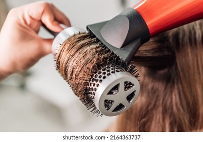 Drying blonde hair with a hair dryer and a round brush. High quality photo - Powered by Shutterstock