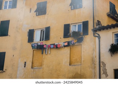 Drying clothes on a line in front of a yellow house