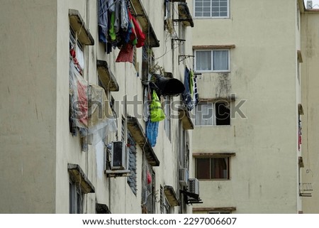 Drying laundry on window with rain protection in high-rise residential buildings. Resourcefulness in deprived neighbourhoods. Glimpse of authenticity during exploration of urban areas while traveling.