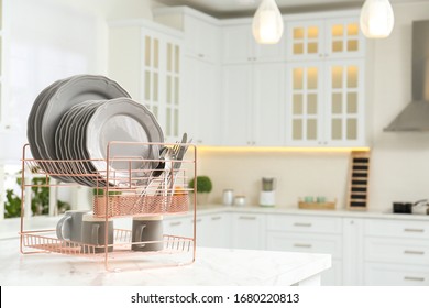 Drying Rack With Clean Dishes On Table In Kitchen. Space For Text