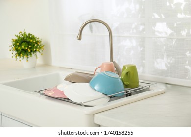 Drying Rack With Clean Dishes Over Sink In Kitchen