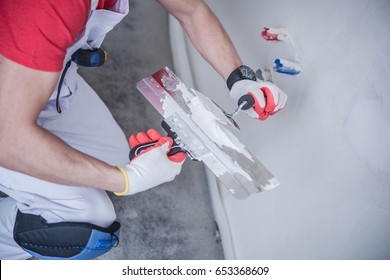 Drywall Patching Job. Apartment Remodeling. Caucasian Construction Worker With Patching Material And Tools.