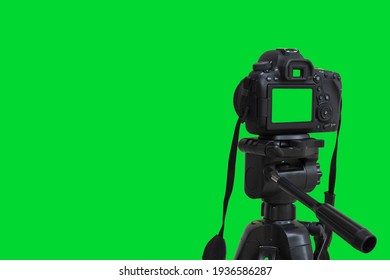 Dslr camera with green screen on the tripod isolated on green background. Green screen camera