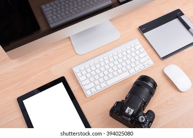 DSLR digital camera with tablet and computer PC on wooden desk table - Shutterstock ID 394025080