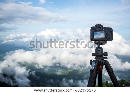 Dslr digital professional camera stand on tripod photographing mountain, Blue sky and cloud landscape. nature background.image,picture on screen.dslr camera shoting nature landscape.camera on a tripod