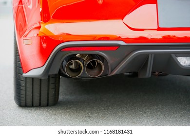 Dual Exhaust On A Modern Sports Car. Red Muscle Car With Big Wheels.