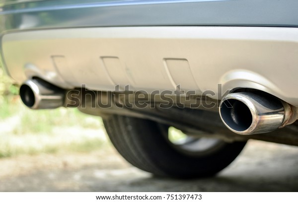 Dual exhaust pipes of modern\
diesel engine car. Detail of extended chromium exhaust pipes\
end.