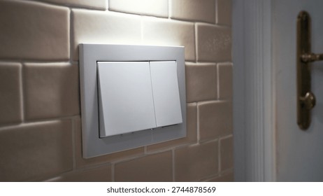 Dual flush wall-mounted button on tiled bathroom wall. Contemporary sanitation technology, water-saving concept, everyday hygiene routine and modern interior details.