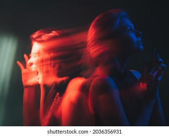 Dual personality. Bipolar mind. Mood disorder. Mental health. Split identity. Woman with depressed peaceful emotion in bright red blue neon light color isolated on dark background. - Shutterstock ID 2036356931