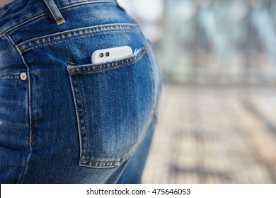 Dual rear lens camera smart phone in back pocket of jeans. Focus on double lens module on silver gadget. Buy this new best phone model of the year to be cool and stay in trend. Trendy new smartphone