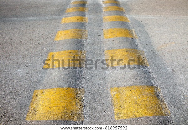Dual speed bump with yellow stripes on the road.\
Algorfa, Spain.