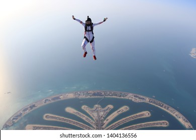 Dubai Adventure Sky Fly Sport.Adrenalin Adventure Flying In Skydive Dubai. Men In White Suit Fly Above Palm. Adventure Background In The Air