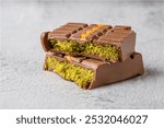 Dubai Chocolate bar with green kadayif and peanut butter on white stone table