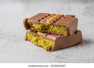 Dubai Chocolate bar with green kadayif and peanut butter on white stone table