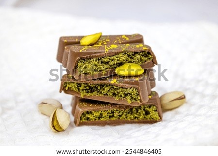Dubai Chocolate bar with green kadayif and pistachio spread with pistachio nuts close up