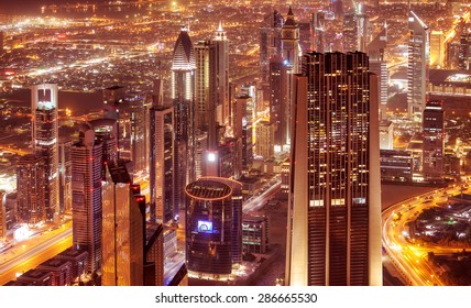 Dubai City At Night, Beautiful Modern Buildings Glowing Lights, Bird Eye View On Gorgeous Cityscape, Famous Business And Travel Destination, United Arab Emirates