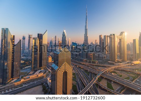 Dubai city skyline panoramic view with metro and cars moving on city's busiest highway