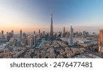 Dubai Downtown day to night transition timelapse with Burj Khalifa and other towers view from the top before new year celebration in Dubai, United Arab Emirates. Lights turning on.