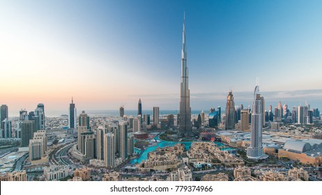 Dubai Downtown day to night transition timelapse with Burj Khalifa and other towers view from the top before new year celebration in Dubai, United Arab Emirates. Lights turning on. Pan right