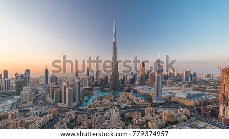 Dubai Downtown day to night transition timelapse with building in Dubai and other towers view from the top before new year celebration in Dubai United Arab Emirates. Lights turning on. Zoom in
