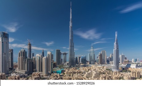 Dubai Downtown skyline all day timelapse with Burj Khalifa and other towers paniramic view from the top in Dubai, United Arab Emirates. Shadows moves very fast. Traffic on circle road and fountains