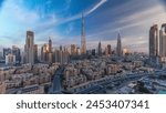 Dubai Downtown skyline with Burj Khalifa and other towers with long shadows during sunrise panoramic view from the top in Dubai, United Arab Emirates. Traffic on circle road and old style buildings