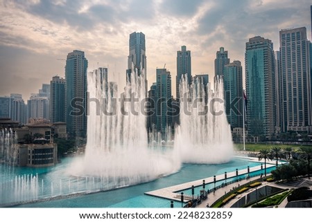 The Dubai Fountain, largest choreographed fountain system in the world. Fountain performing on a powerful beat matching the moody weather
