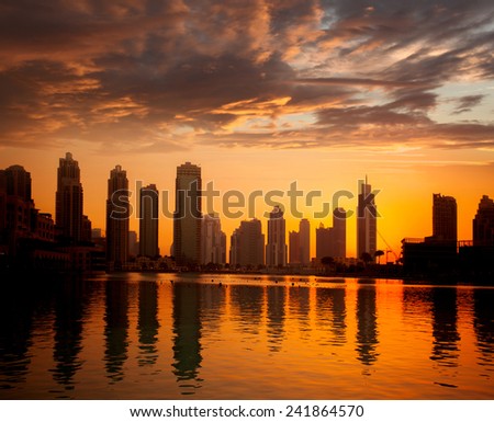 Dubai with golden silhouette of downtown against lagoon in United Arab Emirates