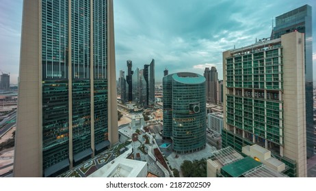 Dubai International Financial Center Skyscrapers Panorama Aerial Night To Day Transition Timelapse. Illuminated Towers View From Above Before Sunrise With Cloudy Colorful Sky