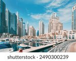 Dubai Marina Port, UAE, United Arab Emirates. Yachts are moored at city pier, jetty in Dubai Marina. Cityscape skyline. Skyscrapers in Dubai.