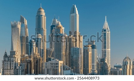 Dubai Marina skyscrapers aerial top view at sunrise from JLT in Dubai timelapse, UAE. Modern towers with long shadows moving down and traffic on sheikh zayed road.
